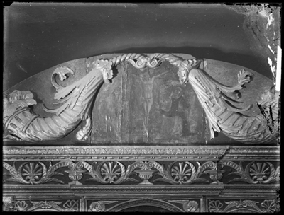 Dettaglio di cornice scolpita con dipinto della crocifissione al centro